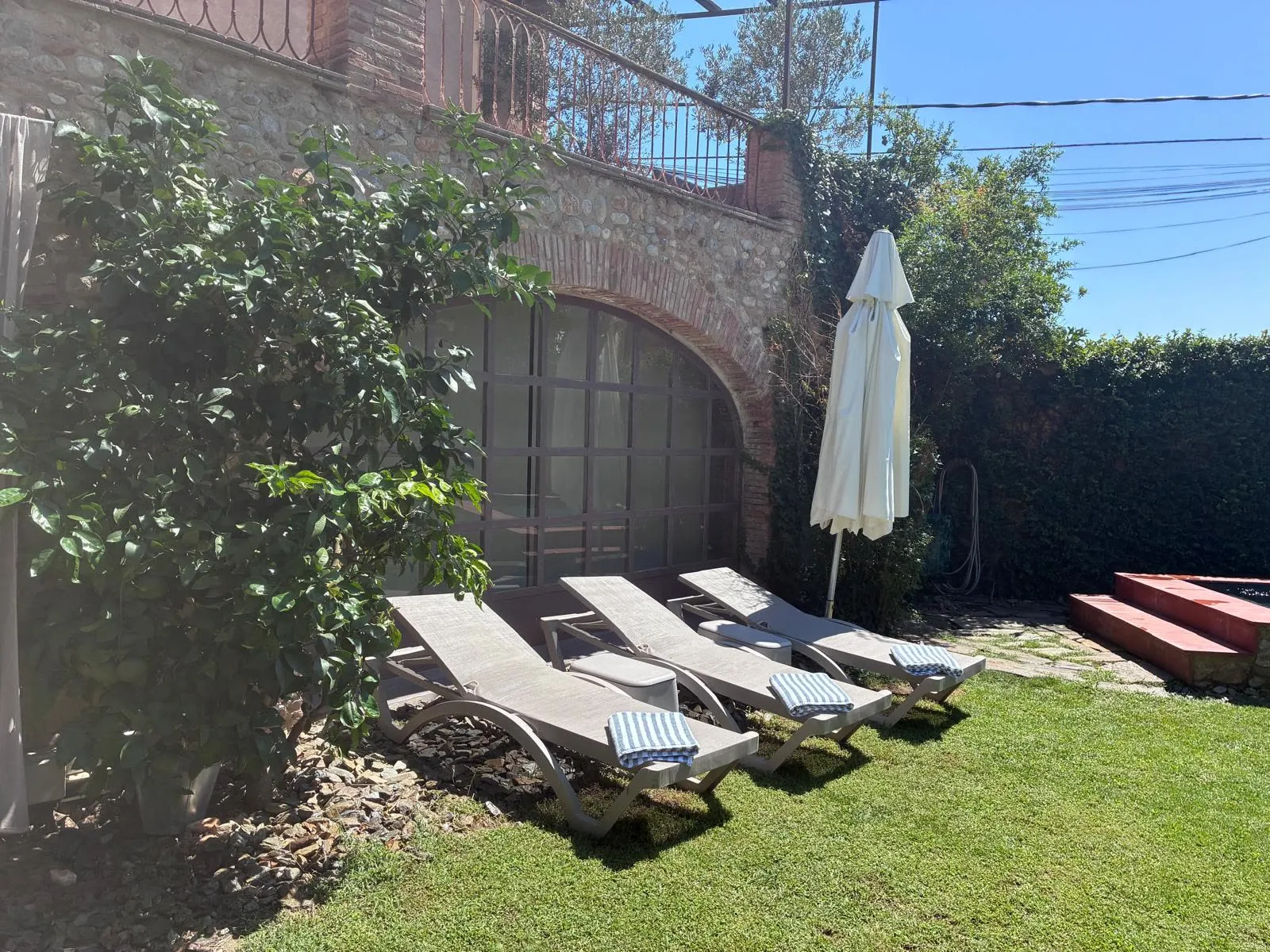 Poolside sun loungers with towels on the lawn
